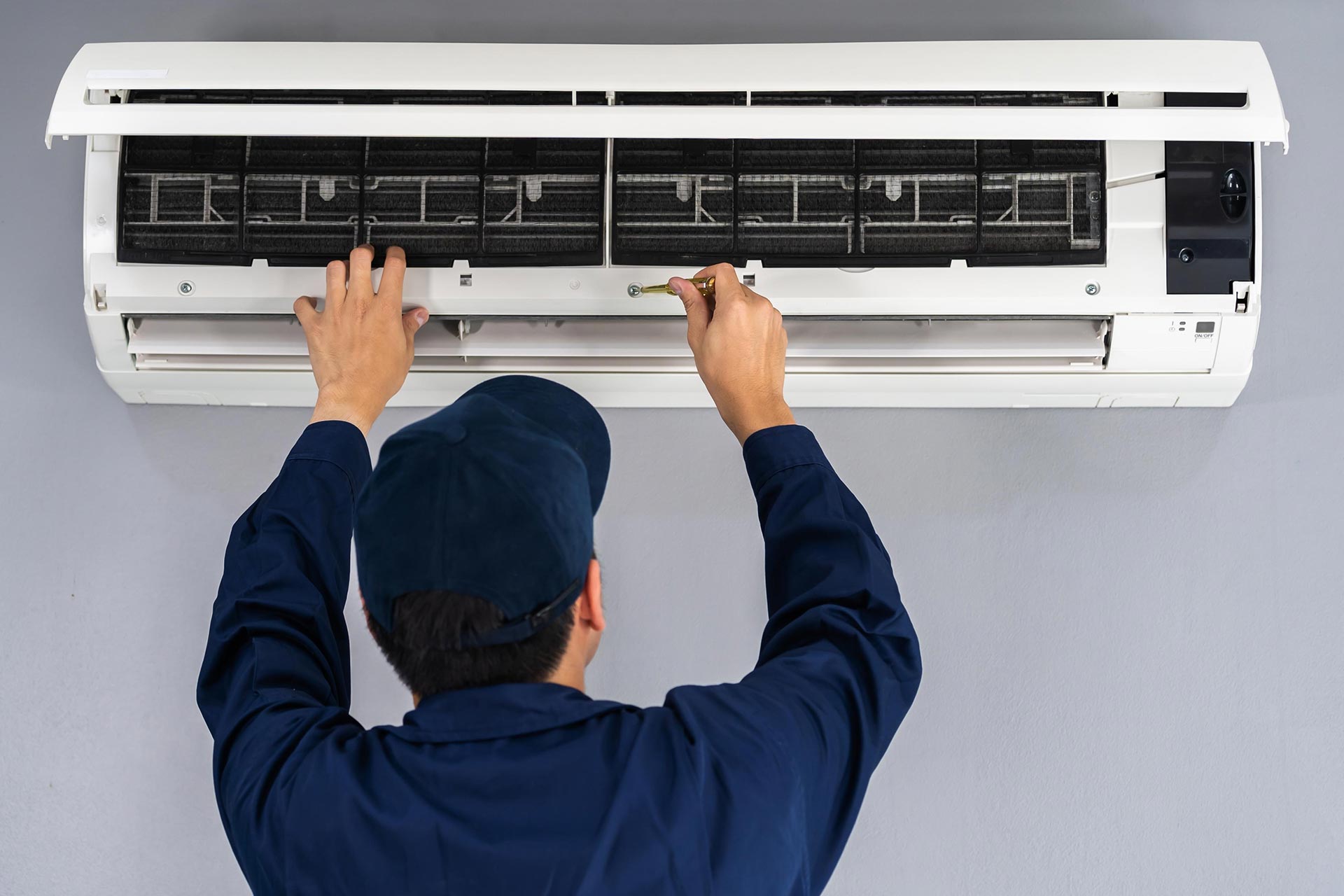 hvac company worker inspecting an AC unit